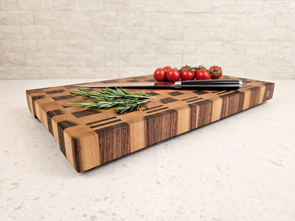 Wooden cutting board with a knife and vegetables on a light surface